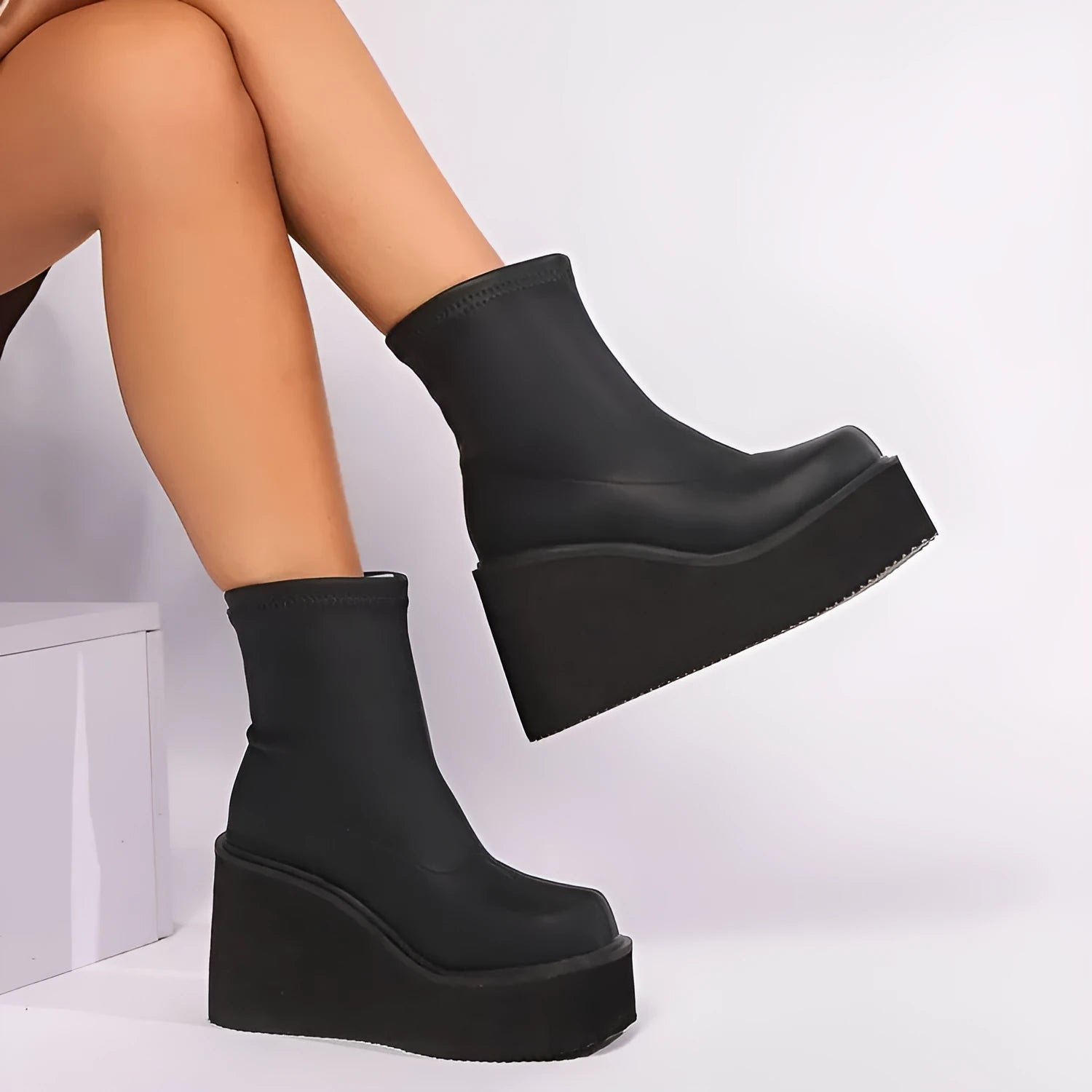 Plus size women's black faux leather wedge heel ankle boots with round toe on a waterproof platform sole.