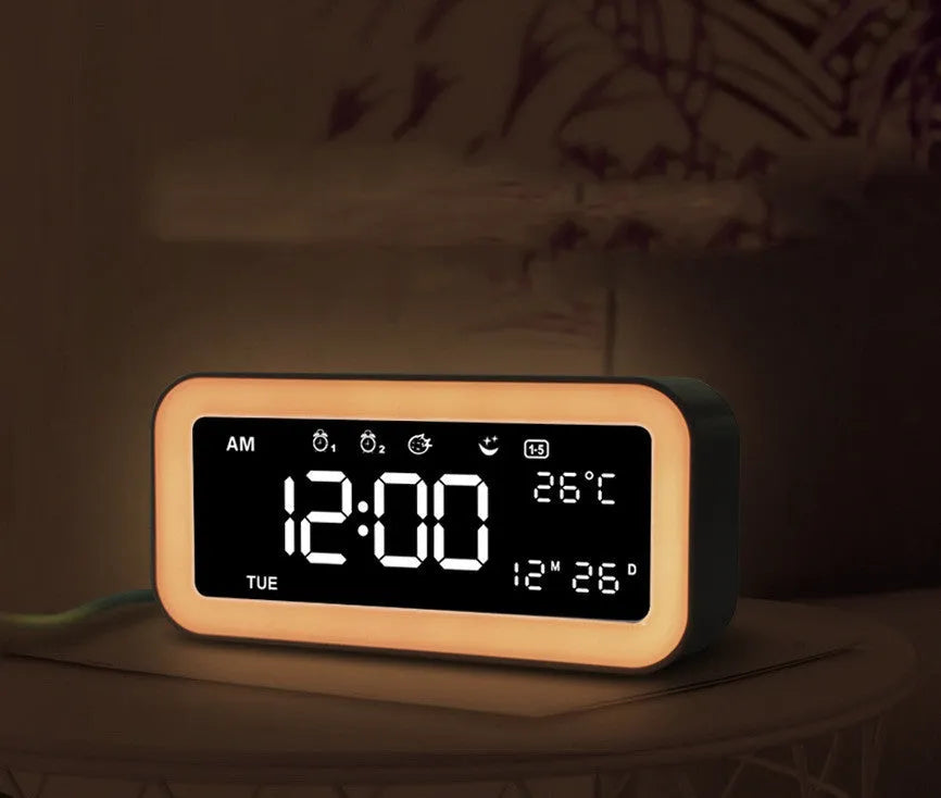Rectangular blue LED alarm clock with digital display and multicoloured atmospheric lighting on bedside table