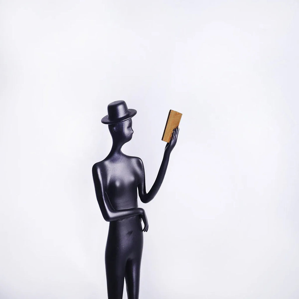 Black cast aluminium desktop sculpture of reading woman figure, modern design