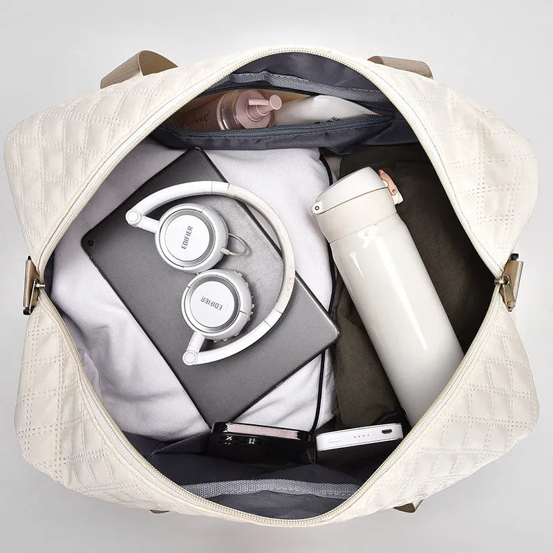 Large Oxford cloth travel bag in a solid colour with contrast stitching, shown with buggy and travel items.