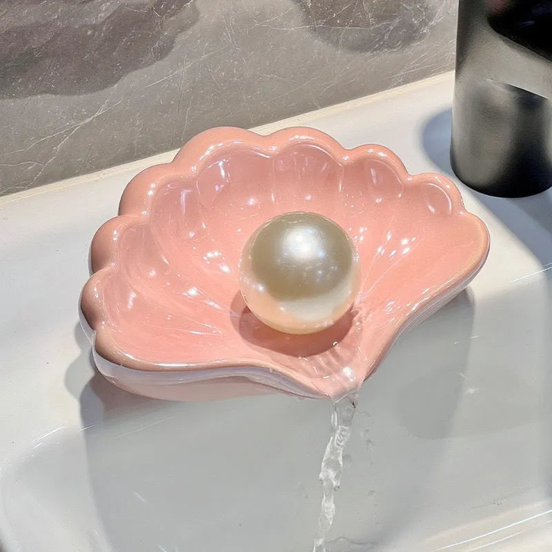 White and pink shell-shaped plastic soap dish for bathroom counter organisation.