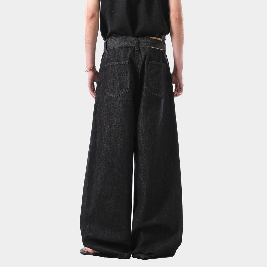 Black high waisted straight leg jeans with gold accents and zip fly opening