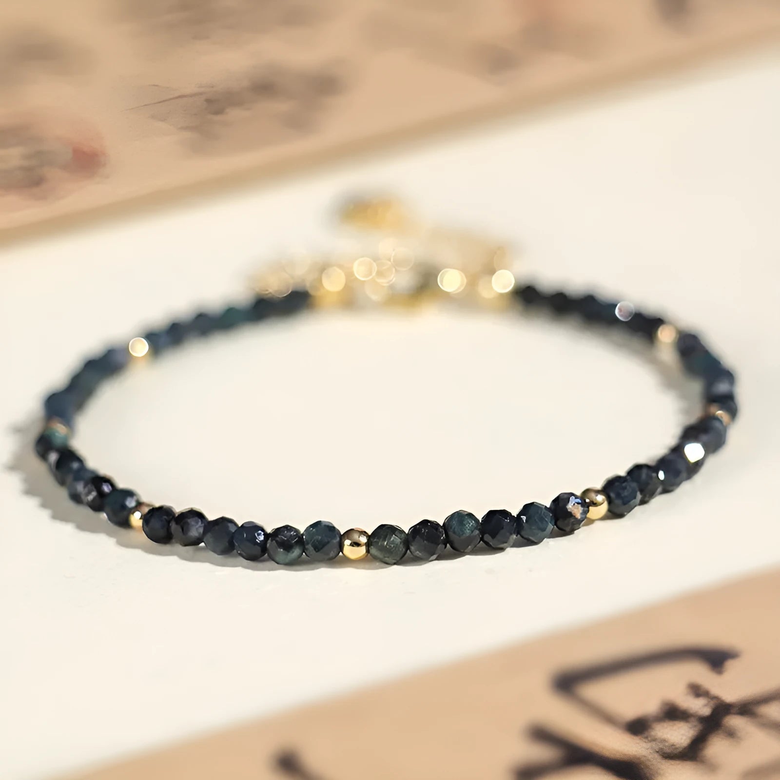 Close-up of a women's bracelet with small blue tourmaline beads and spacer beads on a wrist.
