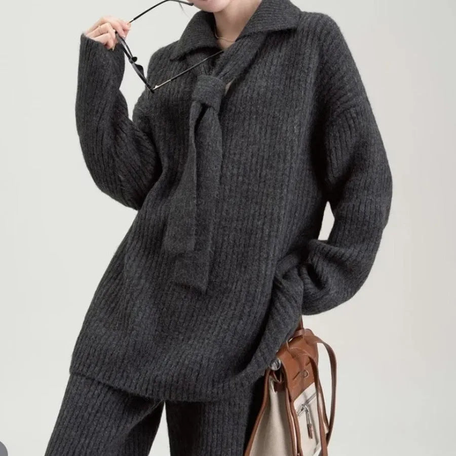 Beige acrylic imitation cashmere knitted top and trouser two-piece set on a hanger.