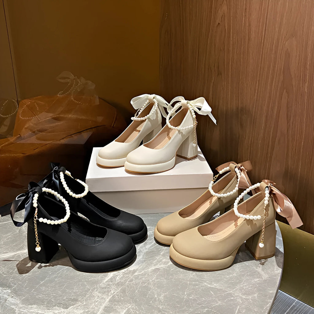 Beige women's Mary Jane shoes with a chunky block heel, ankle strap buckle, and round toe with pearl detail.