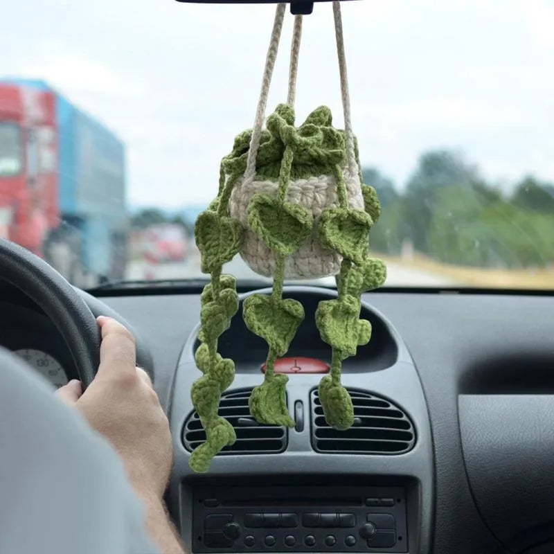 Green and white crochet knitted car plant decoration with rattan basin and white rope.