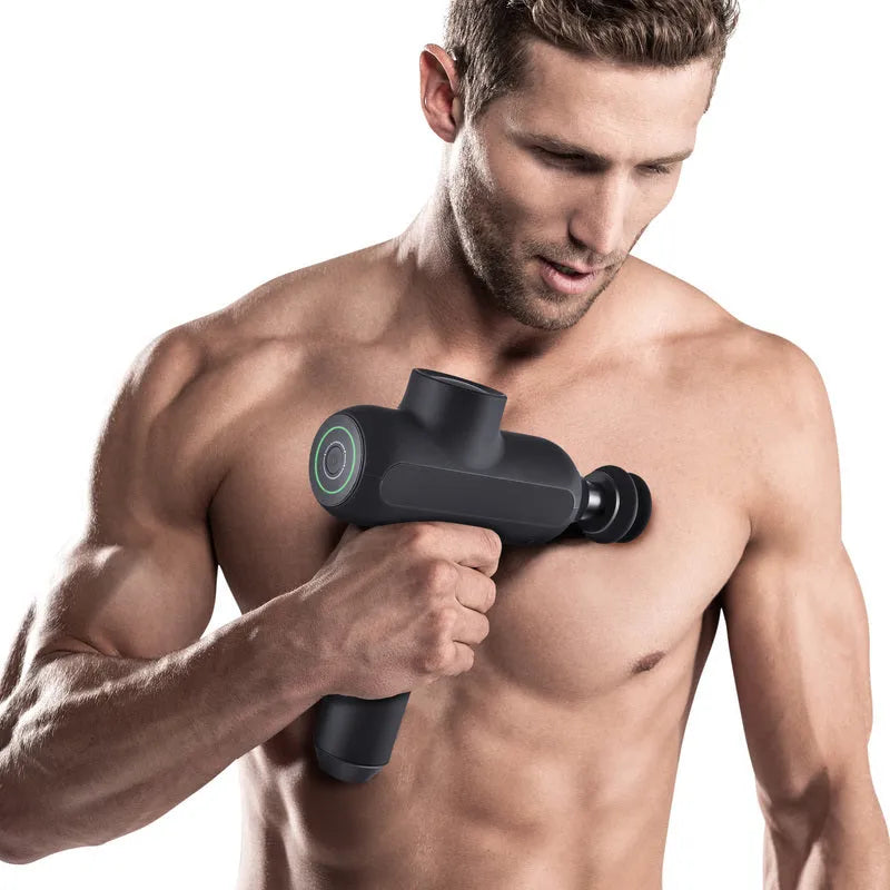 Black electric percussion muscle massager with six different coloured attachment heads on a table.