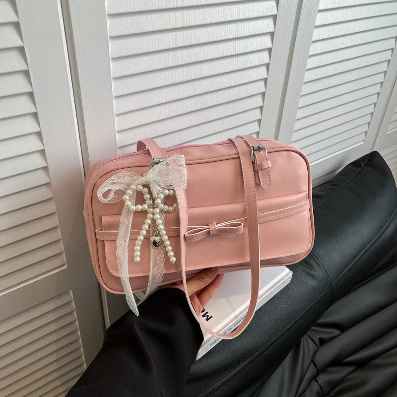 A horizontal square PU flap handbag in a solid colour with double-joint shoulder straps and optional pearl bow ornament.