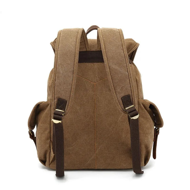 Retro military green canvas backpack with antique bronze hardware, shown with a laptop.