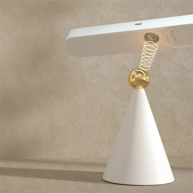 Geometric white desk lamp with magnetic base and USB cable on wooden table