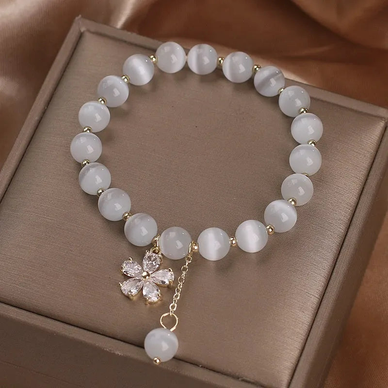 Single loop white cat's eye crystal bracelet with flower tassel and morganite safety buckle for women.