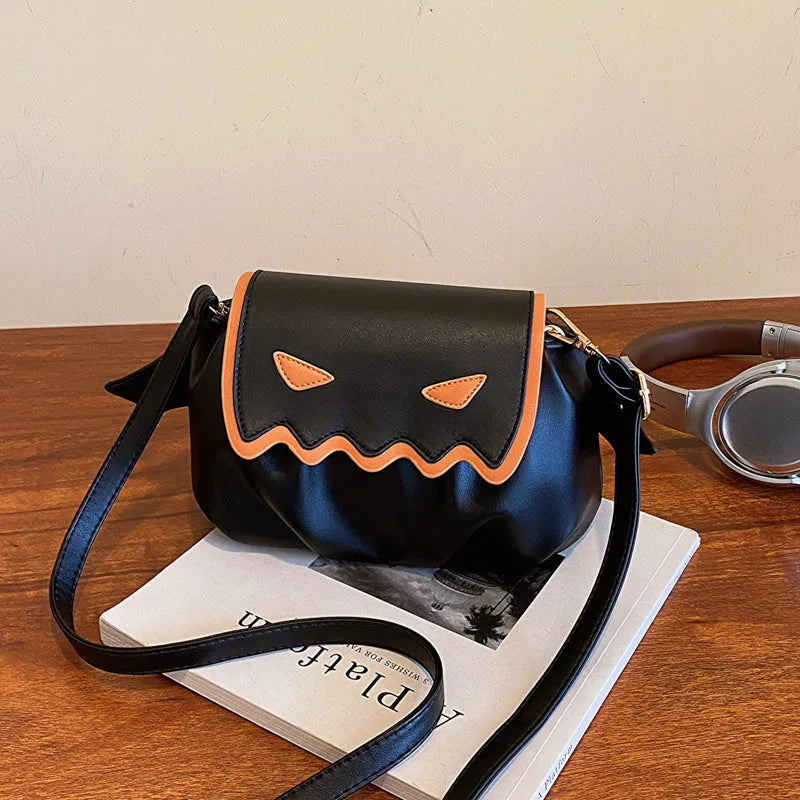 Orange PU crossbody bag with pumpkin cartoon shape and small wings, placed on a neutral background