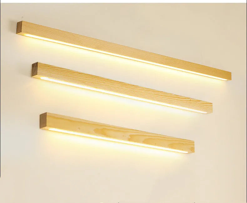 Walnut-coloured linear wood and acrylic strip wall lamp mounted on a light wall.