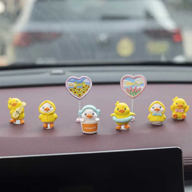 Set of six small PVC cartoon duckling figurines and one rectangular sign for car interior decoration