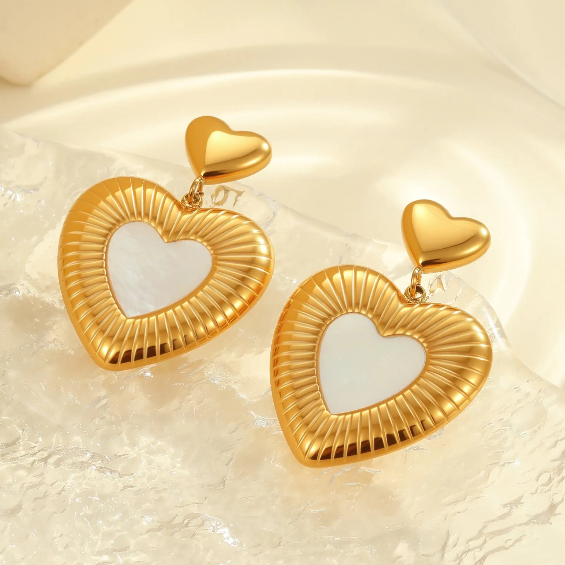 Heart shaped stainless steel earrings with white fritillary pattern and 18K gold electroplated finish