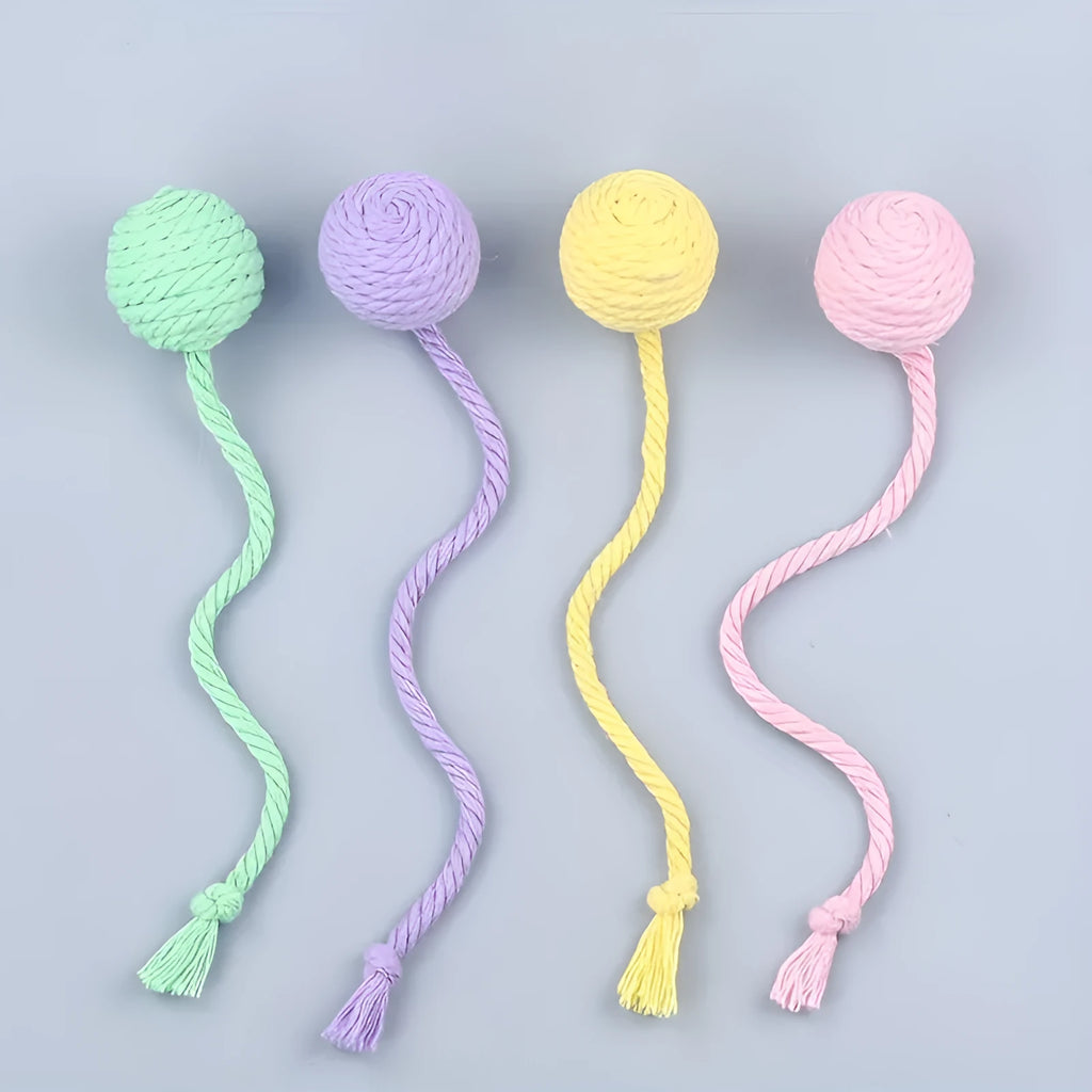Green cat toy ball with attached rope on a wooden floor, shown next to a yellow 3cm size version.