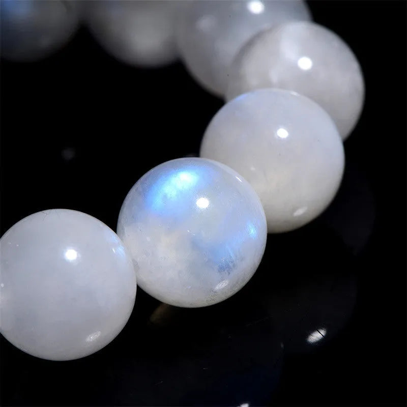 Polished natural blue moonlight moonstone round bead bracelet on white background, showing geometric facets.