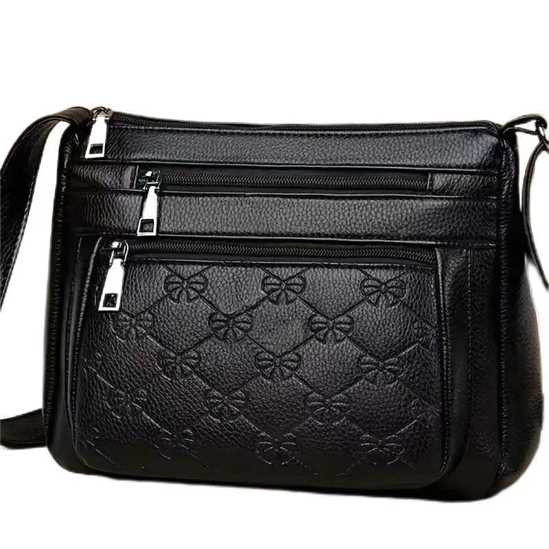 Black women's crossbody bag with butterfly embossed pattern and adjustable shoulder strap.