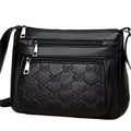 Black women's crossbody bag with butterfly embossed pattern and adjustable shoulder strap.
