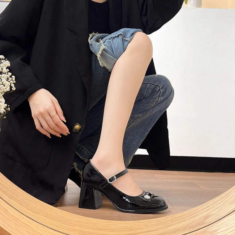 Women's black patent leather chunky heel round toe high heels with ankle buckle.