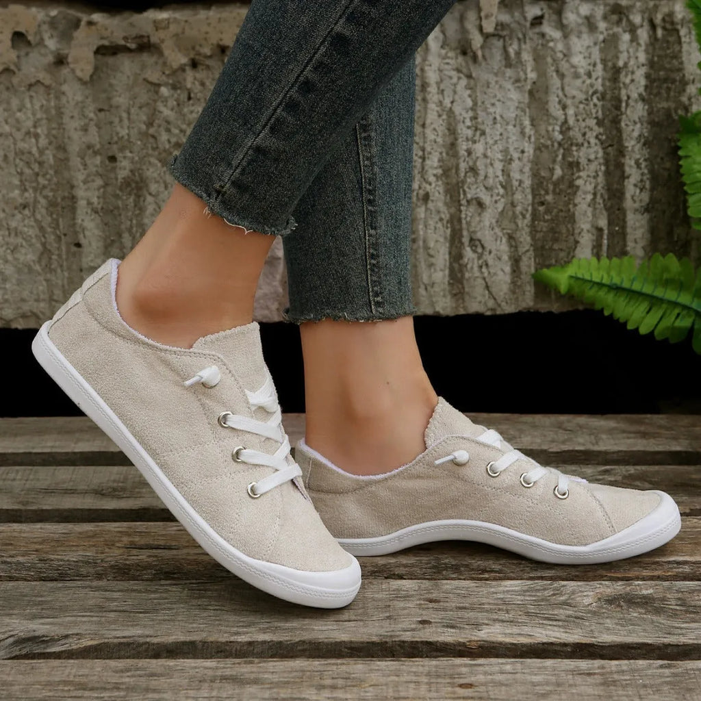 Women's creamy white low-top casual sneakers with fabric upper and rubber outsole on a neutral background