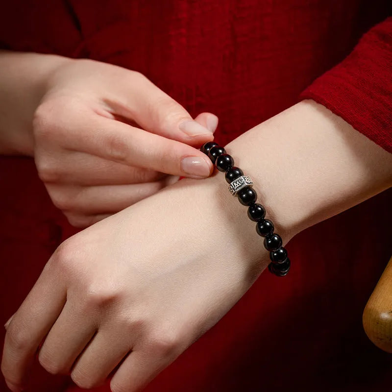 Obsidian bracelet with 8mm beads carved with zodiac animals and bodhisattva figures.
