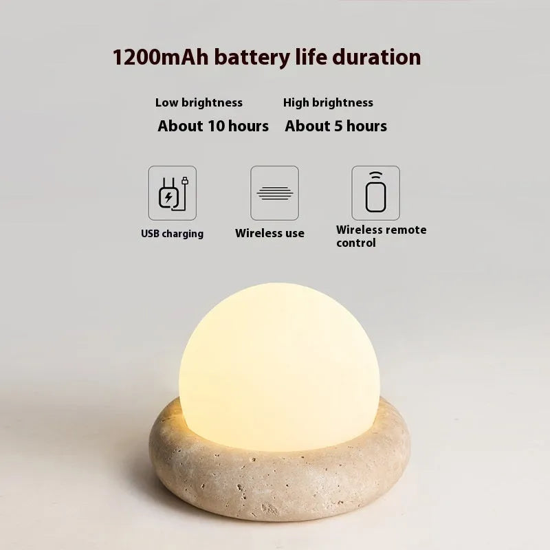Cream coloured remote control bedside night lamp with yellow cave stone light on wooden table