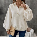 Women's beige textured polo collar long sleeve polyester sweater on a hanger.
