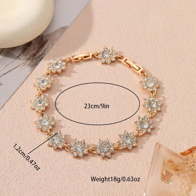Floral shaped zinc alloy bracelet with electroplated silver finish and red coloured gemstones.