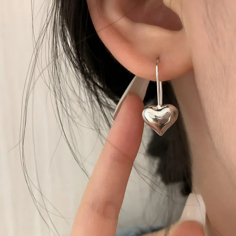 Silver heart shaped earrings with glossy three-dimensional Korean style design