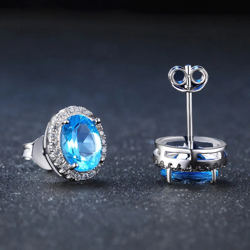 Women's 925 sterling silver and blue topaz four-piece jewellery set with geometric design, showing earrings, ring, necklace, and pendant.