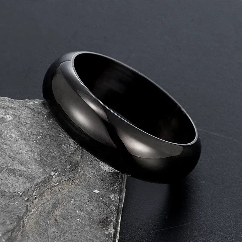 Glossy electroplated titanium steel ring in gold colour on a plain background.