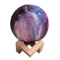 3D printed spherical lunar night light on a table showing colour-changing LED illumination.