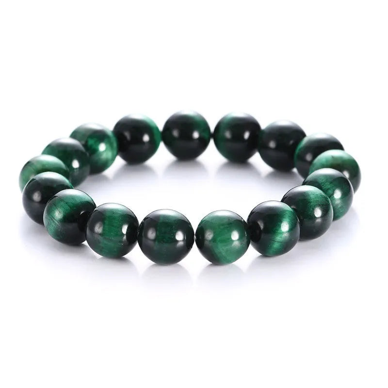 Green tiger eye stone bead bracelet with geometric polished beads on a wrist.