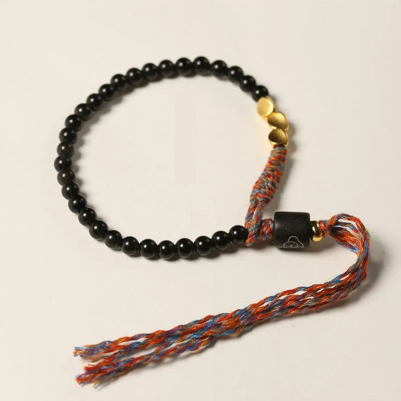 Hand-woven obsidian-coloured strap bracelet showing textured surface and slim 4mm width