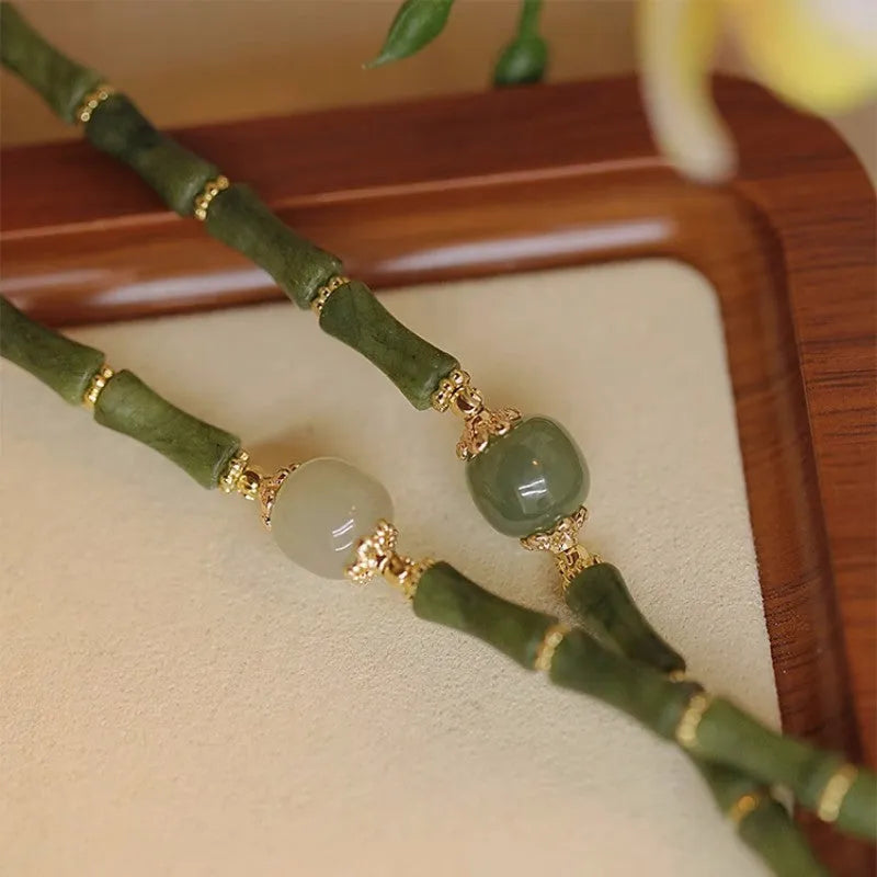 Women's simple geometric Hetian jade bracelet in dark green and light colour on a white background.