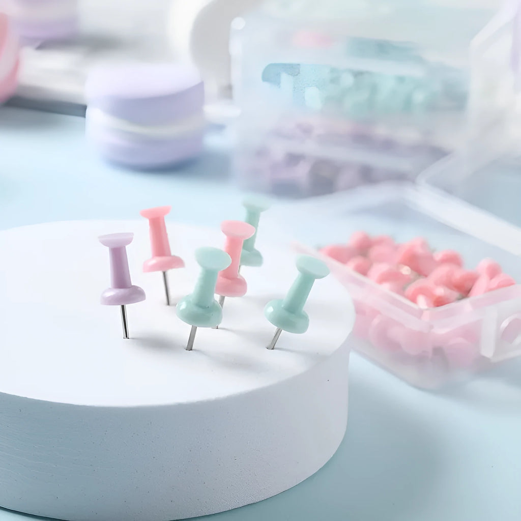 Box of plastic push pins in large and small sizes showing cherry blossom pink, mint green, and lavender colours.