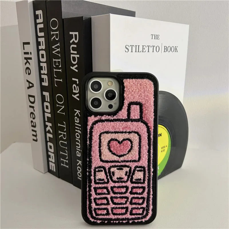 Pink iPhone back cover with a raised embroidered towel pattern design.