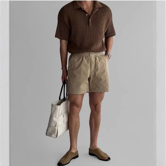 Men's loose-fit cotton sports shorts in khaki colour on a hanger.