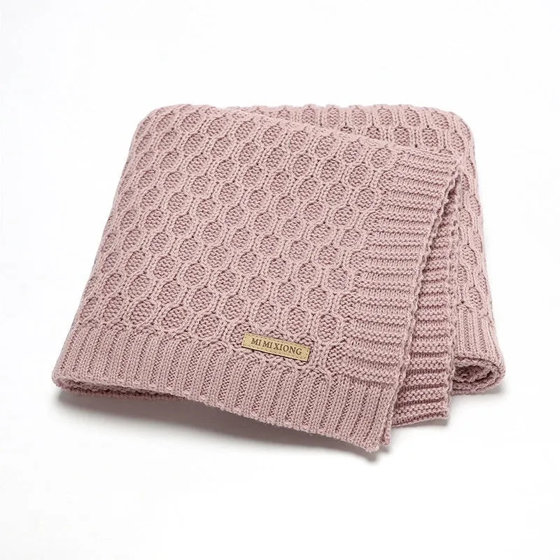 Solid colour infant hug blanket with textured three-dimensional lines, shown in a light colour option.