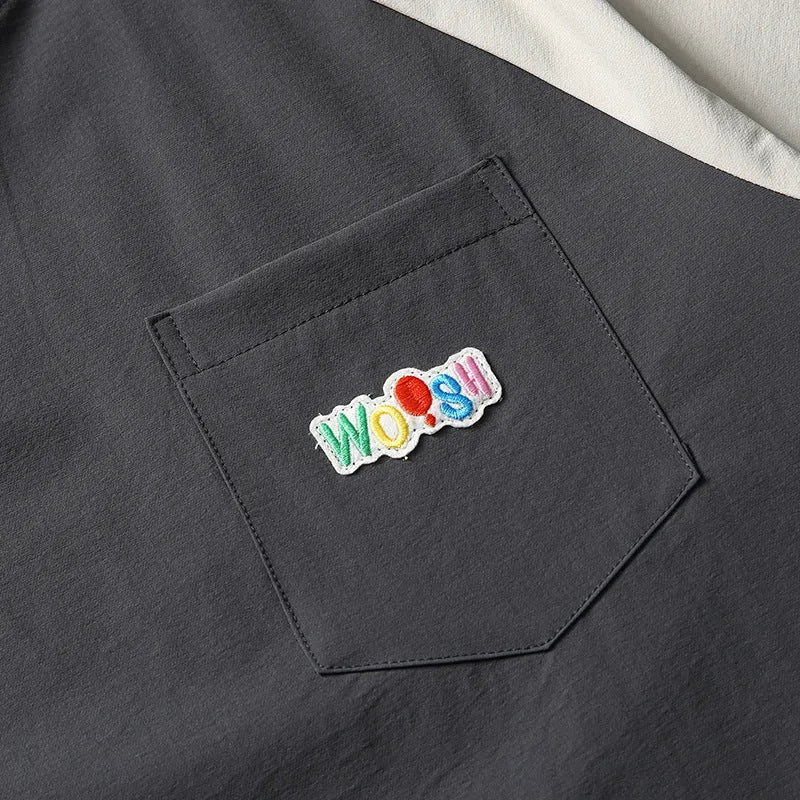 Dark grey loose fit T-shirt with contrasting colour raglan short sleeves on a hanger