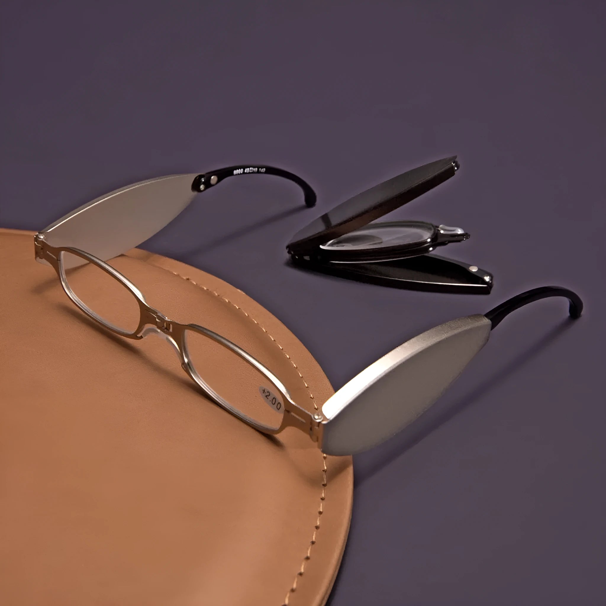 Folding reading glasses with retro metal frame in black and silver colours, showing compact folded size