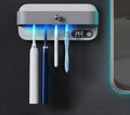 White wall-mounted smart toothbrush steriliser holder with USB charging port and control button.