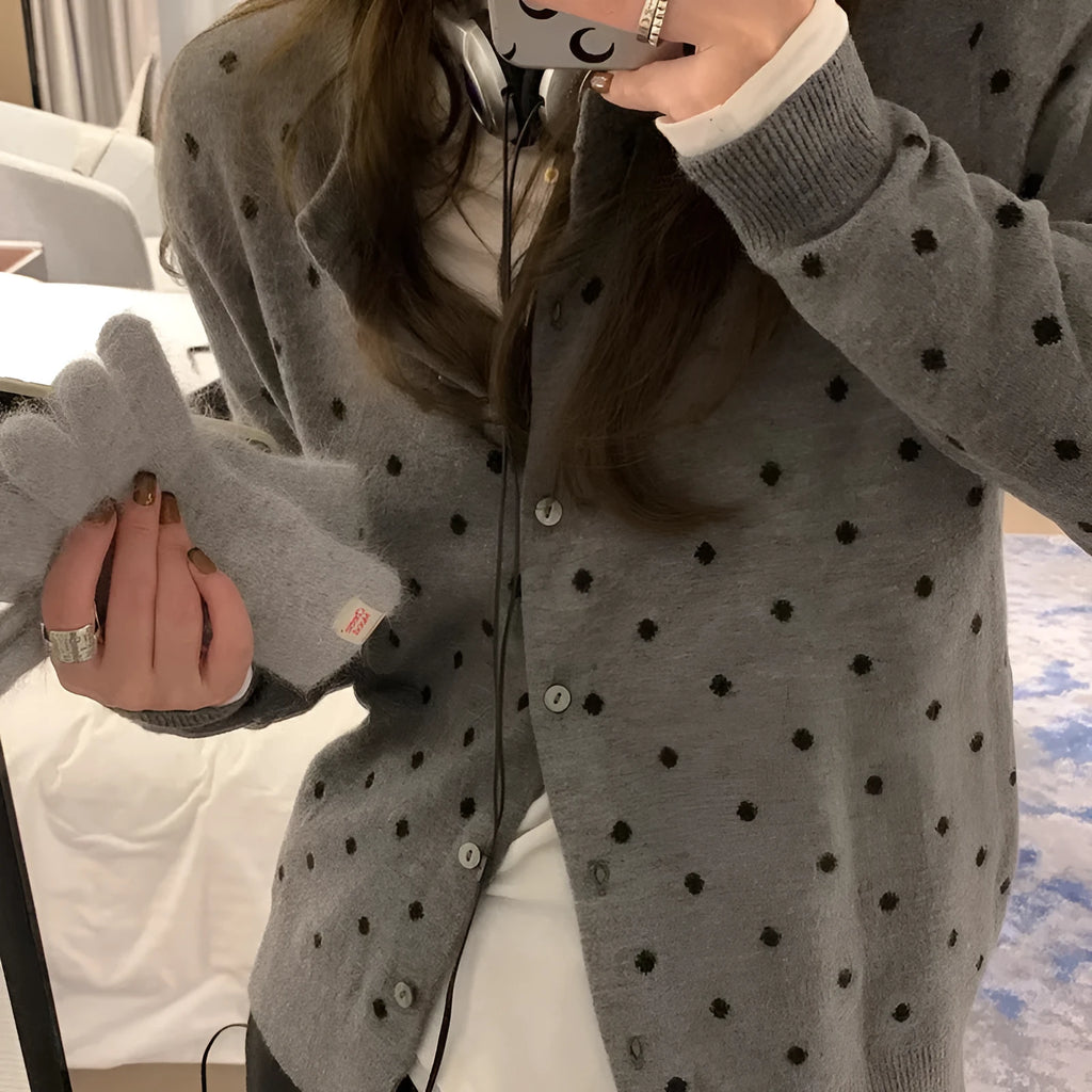 Women's grey loose-fit knitted cardigan with long sleeves on a hanger.
