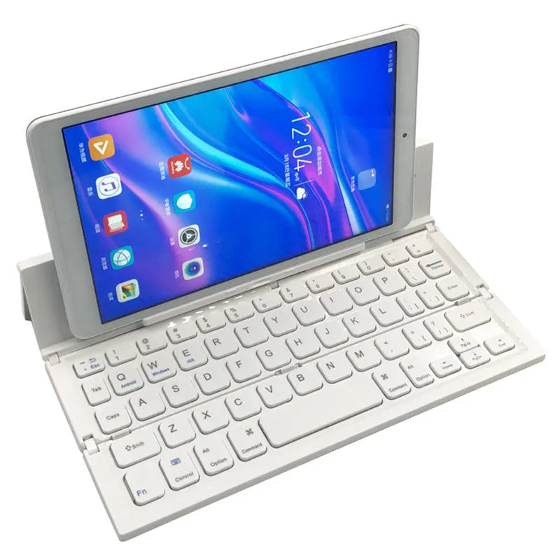 Black folding wireless Bluetooth keyboard shown open next to a tablet demonstrating its compact portable size.