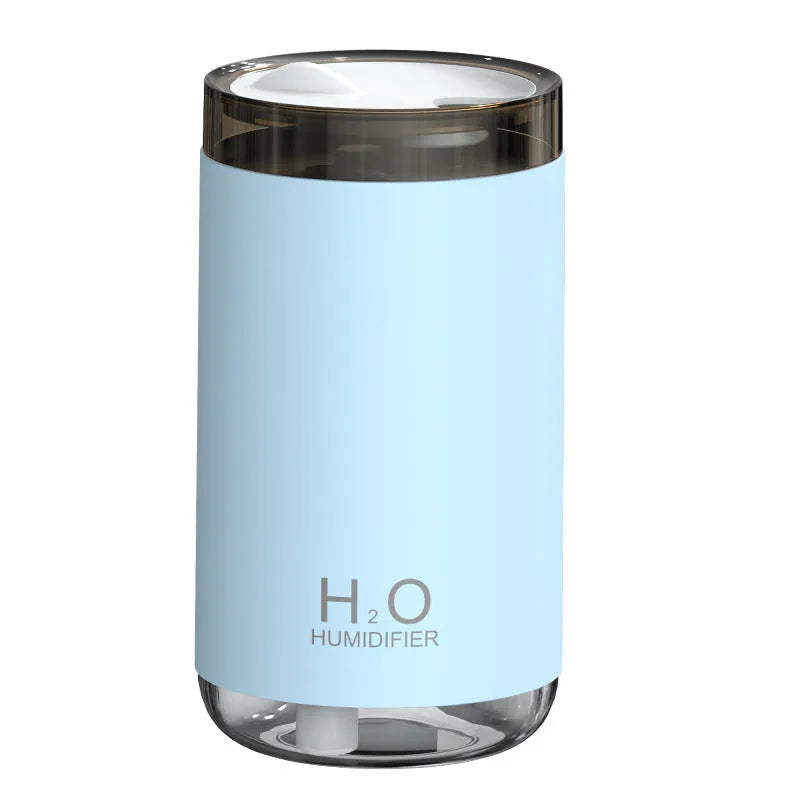 White jellyfish USB humidifier with night light on wooden surface showing mist output