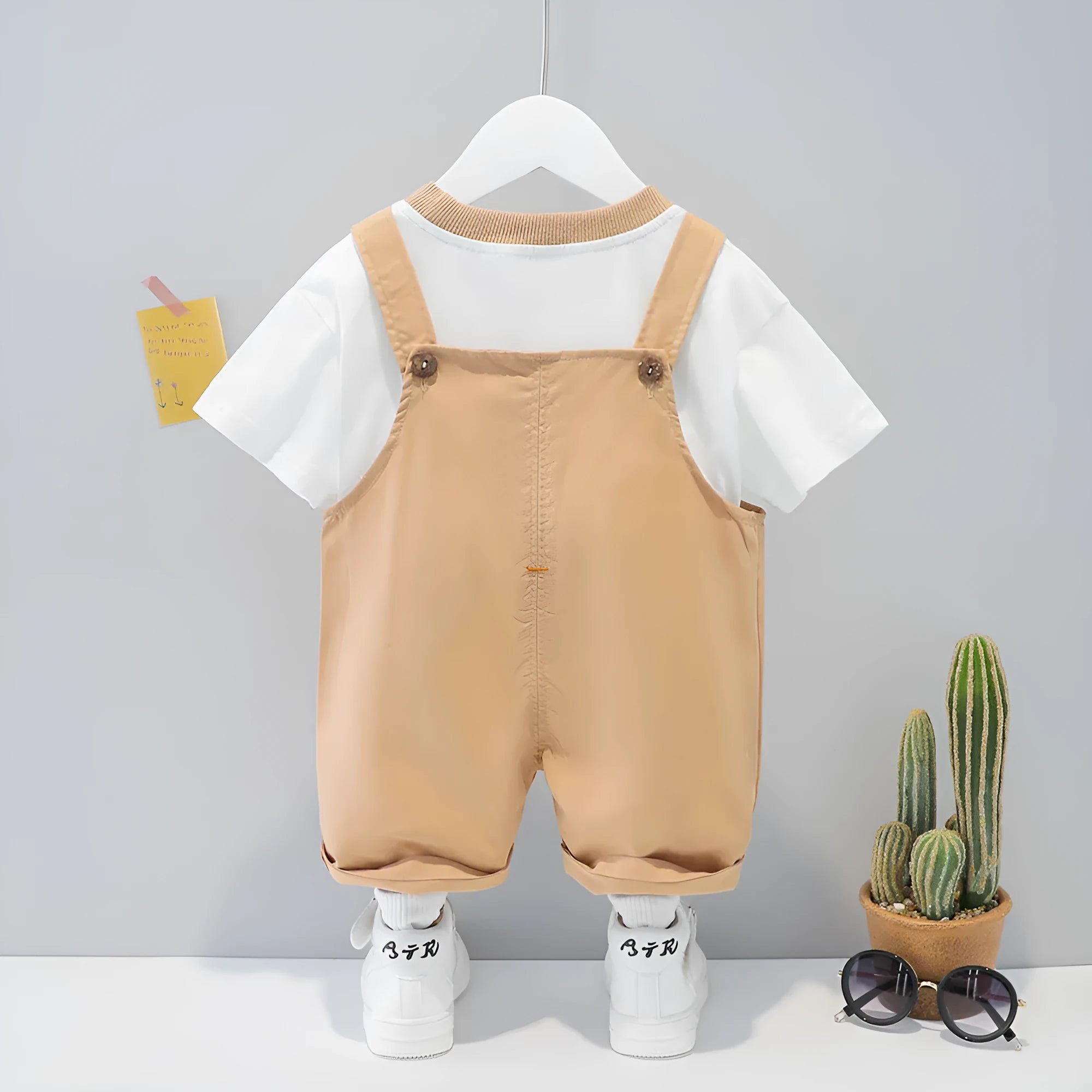 Baby wearing yellow cotton cartoon overalls with short sleeves and adjustable straps