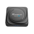 Compact black Android 11 TV box with remote control and HDMI cable on a table