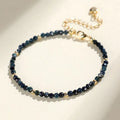 Close-up of a women's bracelet with small blue tourmaline beads and spacer beads on a wrist.