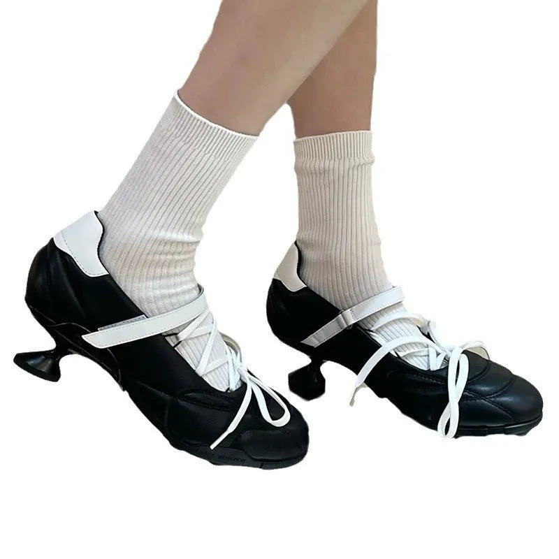 Women's silver sports shoes with a front lace-up bow and a mid heel on a white background.